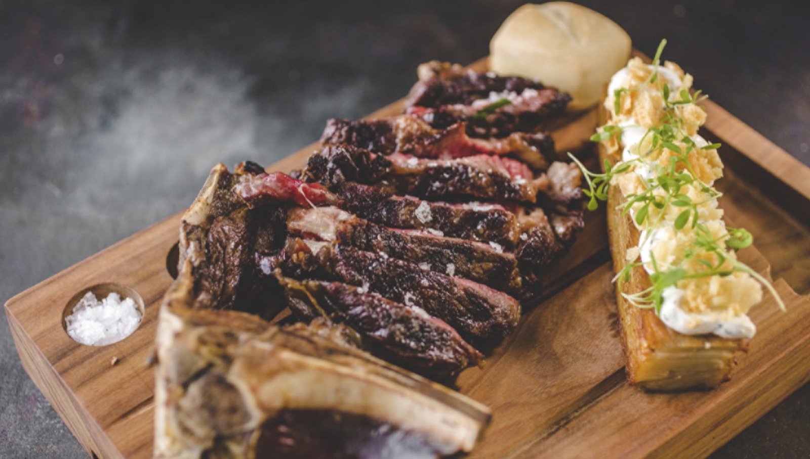 Angus rib eye served on a board at Elena